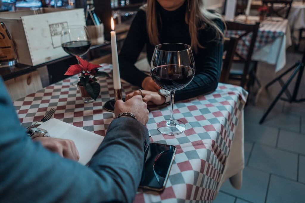 Imagem de um casal jantando tomando vinho