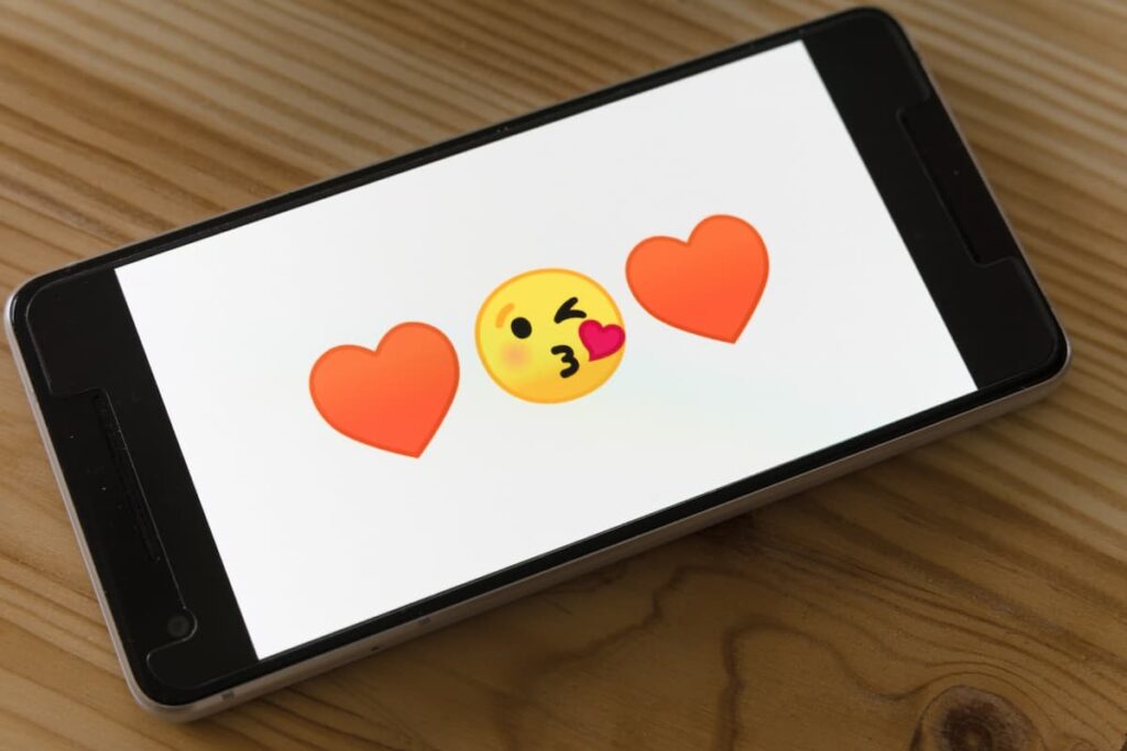 Imagem de um celular com emojis românticos