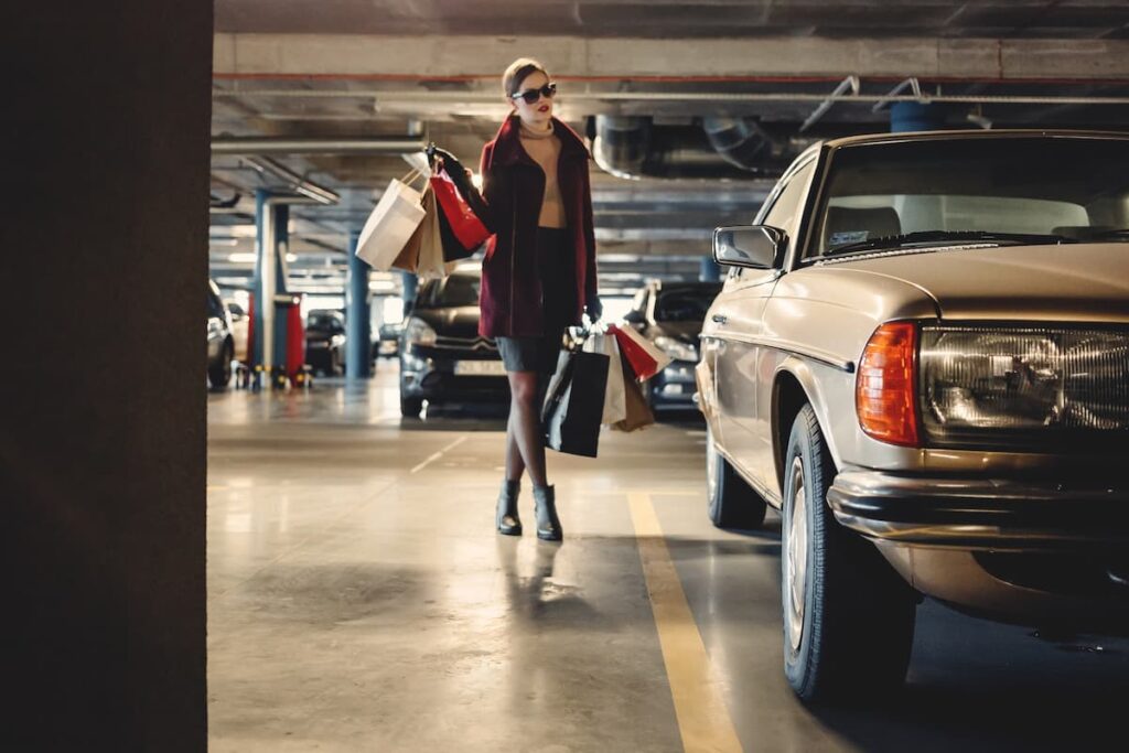 Mulher andando em direção ao carro no estacionamento do shopping