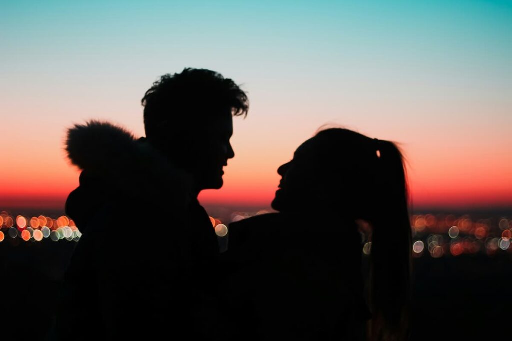Imagem de um casal em um pôr do sol abraçados