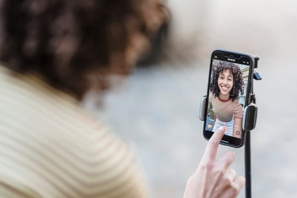 Imagem de uma mulher tirando foto sozinha em seu celular no suporte