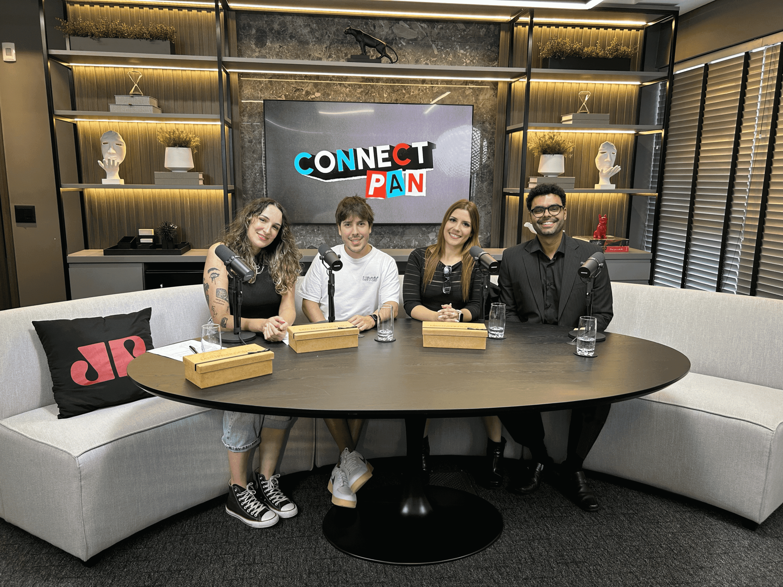 Quatro pessoas participando do programa Connect Pan em um estúdio de gravação.
