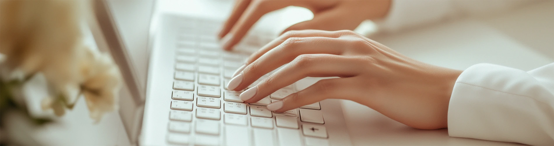 Mãos femininas digitando a bio do MeuPatrocínio em um teclado branco, criando um perfil elegante e bem estruturado.